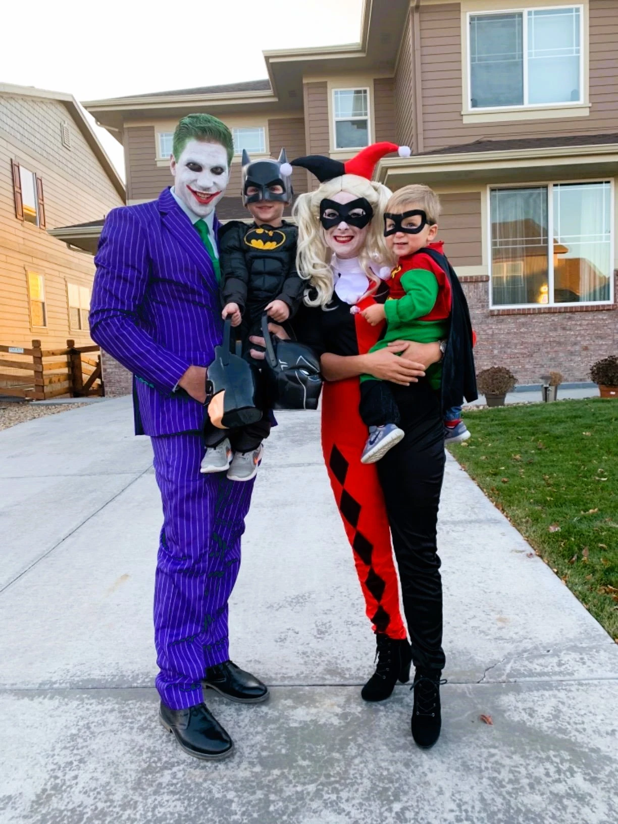 family of 4 Halloween costumes with the Joker, Harley Quinn, Robin, Batman